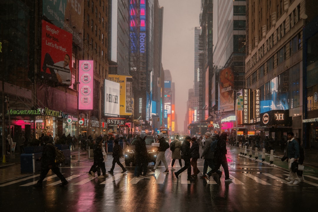 Photo by Bryan Brittos People cross a busy street in a city.