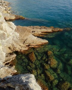 Rocky coastline meets clear turquoise waters.
